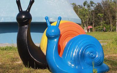 草地上擺放的一黃一藍兩只玻璃鋼彩繪蝸牛雕塑